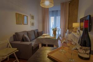 uma sala de estar com um sofá e uma mesa com copos de vinho em Apartamento El Socorro em Ronda