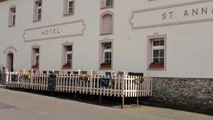 a white building with a fence in front of it at Garni Hotel St Anna in Boží Dar