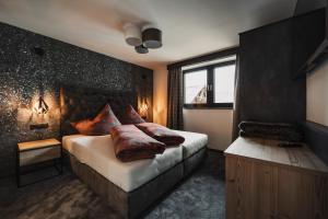 um quarto com uma cama com almofadas em 4zero Appartment em Umhausen