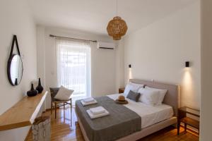a bedroom with a bed and a desk and a window at Seafront Luxury Suite in Rethymno Town