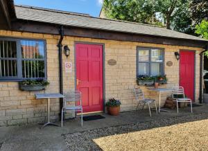 a house with red doors and two tables and chairs at Cross Swords Rooms, Skillington in Skillington