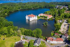 an island with a castle in the middle of a lake at Fjordvejen Apartments in Gråsten