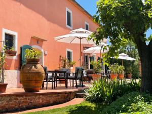 un patio con mesa, sillas y sombrilla en Agriturismo Podere Marchiano, en Larciano