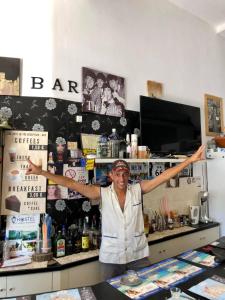 a woman standing in a store with her arms outstretched at Hostel Stylianos Kissamos in Kissamos