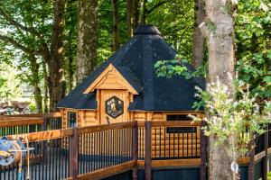 ein Holzhaus mit einer Uhr auf dem Zaun in der Unterkunft Kintala Resort & Spa in Dungiven