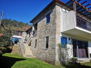 a stone house with a staircase leading up to it at T0 Eira Trás in Vieira do Minho