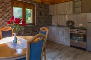 a kitchen with a table with a vase of flowers on it at Brvnara Greben in Timotijevići