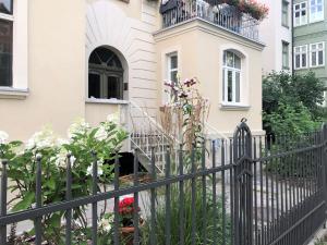 a black fence in front of a house with flowers at VIU Apartamenty Modern Retro z parkingiem in Sopot +24 photos