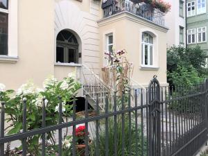 a black fence in front of a house with flowers at VIU Apartamenty Modern Retro z parkingiem in Sopot