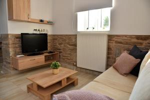 a living room with a couch and a tv at Kampos Family Garden in Batsi