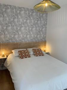 - une chambre avec un lit blanc et un mur dans l'établissement 3 pièces neuf au pied des musées - Wifi & Parking, à Grasse