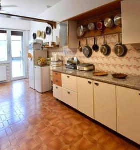 eine Küche mit weißen Schränken und Fliesenboden in der Unterkunft B&B Tou Lì in San Martino