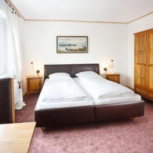 a large bed in a bedroom with two night stands at Landgasthof Löwen in Oberopfingen