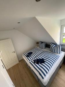 ミデルハーゲンにあるFerienhaus Jolineのベッドルーム1室(青と白のストライプ枕付きのベッド1台付)