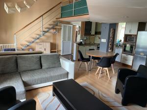 a living room with a couch and a table with chairs at Pláza Home in Siófok