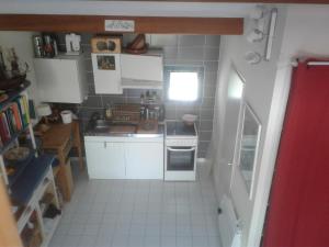 a small kitchen with white cabinets and a window at grand studio de plein-pied quartier calme proche centre in La Roche-sur-Yon
