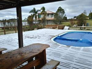 a hot tub sitting on a deck with snow on the ground at A Casa do Rio in Lages