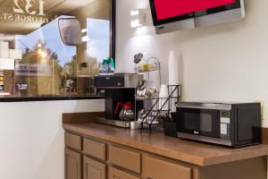uma cozinha com um balcão com um micro-ondas e uma televisão em Red Roof Inn York Downtown em York