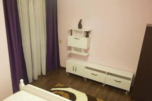 a white bedroom with a bed and a dresser at Home sweet home in Cluj-Napoca