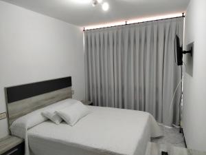 a bedroom with a white bed and a window at A Casa de Lolita in Muros