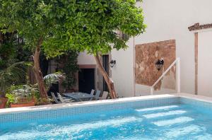 a swimming pool in front of a house with trees at A historic XVI century beach home near Barcelona in Barcelona