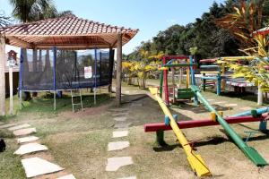 a playground with a swing set and a pavilion at Hotel Alpha Ville Chalés in Conceição da Ibitipoca