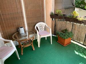 a patio with two chairs and a table and a table and chairs at Pláza Home in Siófok