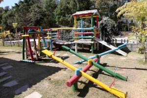 a playground with colorful play equipment in a park at Hotel Alpha Ville Chalés in Conceição da Ibitipoca