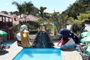 park wodny z dwoma nadmuchiwanymi zwierzętami w basenie w obiekcie Hotel Alpha Ville Chalés w mieście Conceição da Ibitipoca