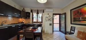 a kitchen with a table and a refrigerator at Casa Tizy in Botrugno