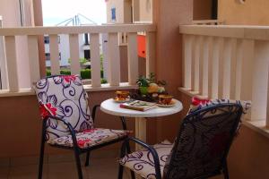 a balcony with two chairs and a table and a window at Agava Apartments Begic in Makarska