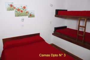 Apartamento El Calvario 3 في تانديل: غرفة نوم بسريرين بطابقين مع شراشف حمراء