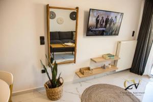 een woonkamer met een spiegel en een bank bij City Vibes apartment Preveza in Preveza