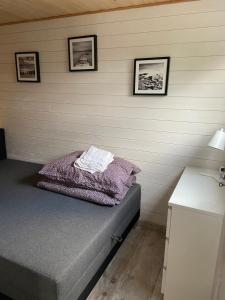 a bed in a room with three pictures on the wall at Domek nad jeziorem Kamień in Kowalewo