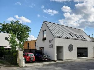 慕尼黑城堡Kafé Ořech的一栋白色建筑，前面停着一辆汽车