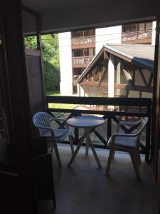 een patio met een tafel en stoelen op een balkon bij Brides-les-Bains family ski and spa appartment in Brides-les-Bains