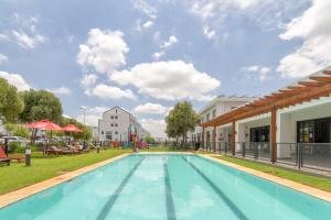 a large swimming pool in a park next to a building at Villa Valentino Greenstone Ridge WiFiNetflix in Edendale