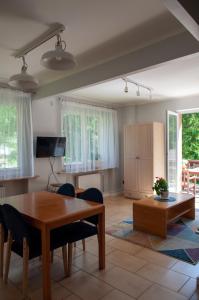 ein Wohnzimmer mit einem Holztisch und Stühlen in der Unterkunft Willa Monti in Szczyrk