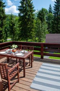 eine Holzterrasse mit einem Tisch und Stühlen darauf in der Unterkunft Willa Monti in Szczyrk