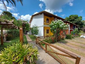 a yellow and white house with a wooden fence at Apartamento lençóis 103 in Lençóis