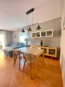sala de estar con mesa, sillas y sofá en CAN LOLA Estupenda casa de 4 habitaciones con jardín a 150 metros de la playa en Torredembarra