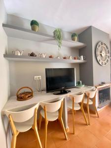 comedor con mesa con sillas y TV en CAN LOLA Estupenda casa de 4 habitaciones con jardín a 150 metros de la playa en Torredembarra
