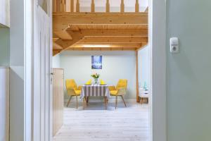 a dining room with a table and yellow chairs at Central Studio Budapest in Budapest