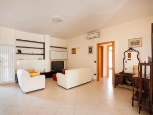 een woonkamer met twee witte stoelen en een televisie bij Residenza Le Fontanelle in Gallipoli