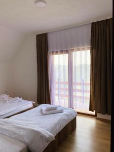a hotel room with two beds and a window at Villa Liqenat in Boge