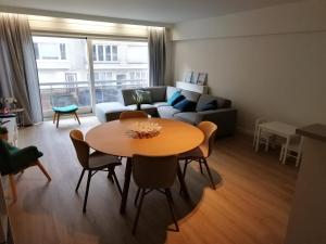 a living room with a table and a couch at Hakuuna Matata Appartement Koksijde in Koksijde
