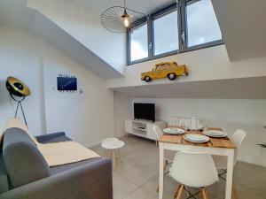 a living room with a table and a yellow car on the wall at Stop Chez M District # Qualité # Confort # Simplicité in Villeurbanne