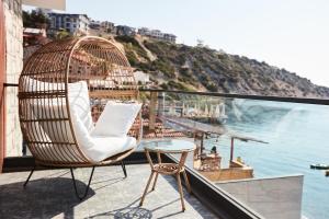 einen Rattansessel auf einem Balkon mit Meerblick in der Unterkunft Casa Mimosa Hotel in Izmir