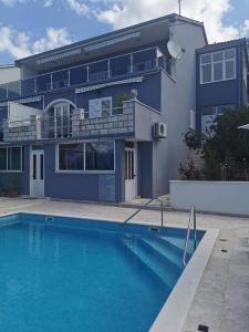 uma casa com piscina em frente a uma casa em Apartments Marija - 10m from beach em Trogir