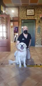 un hombre con una máscara sentado al lado de un perro en HOTEL OS PAZOS familiar, en Cambados